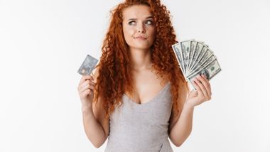 A girl choosing between a card and cash